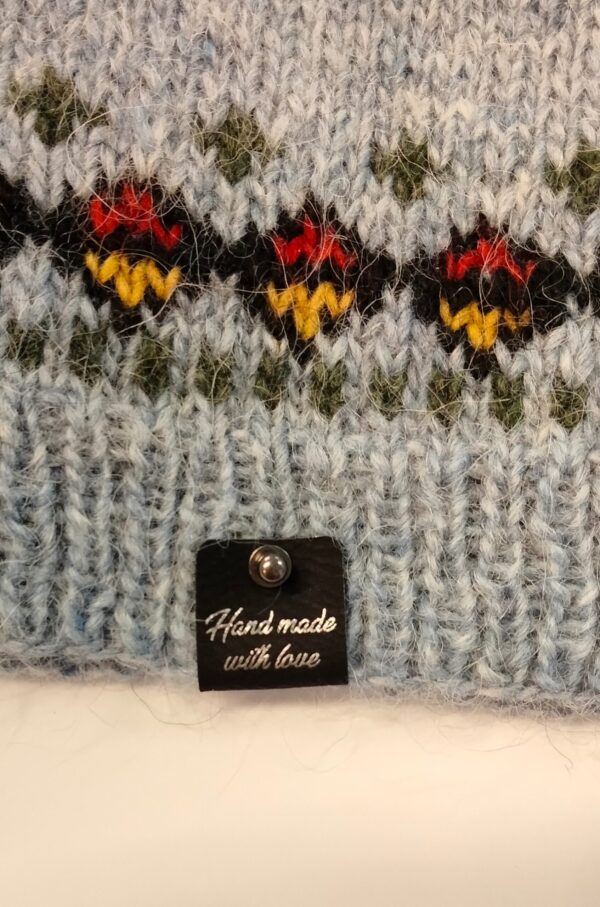 Hand made with love -merkki kiinnitettynä puseron helmaan.
