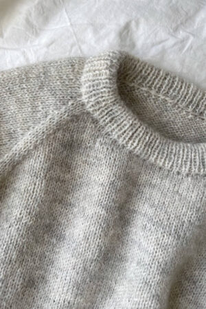 Vaaleanharmaa PetiteKnit Monday Sweater -neulepusero tasolle levitettynä