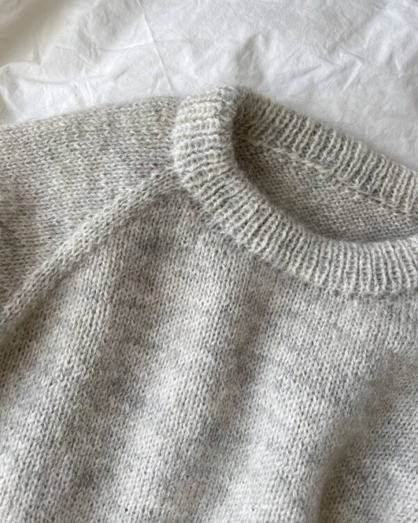 Vaaleanharmaa PetiteKnit Monday Sweater -neulepusero tasolle levitettynä