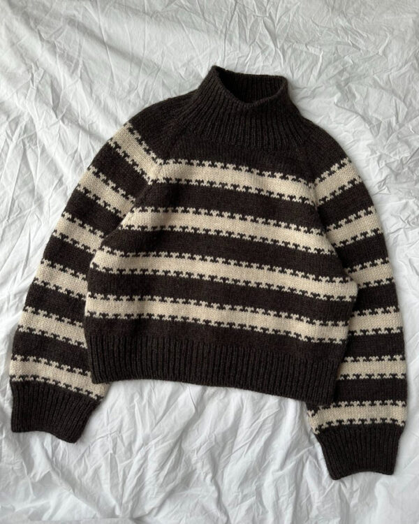 PetiteKnit Key Sweater -neulepuserossa on raitoja, jotka linkittyvät toisiinsa kuvioiden kautta