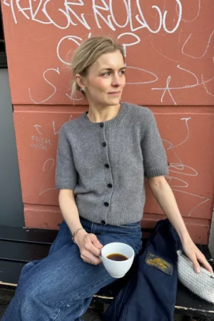 PetiteKnit Maggie Cardigan, malli istumassa penkillä