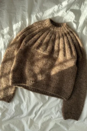 PetiteKnit Sunday Sweater -pusero tasolle levitettynä. Ohje on englanninkielinen. Kaarrokkeen lisäykset tekevät yläosaan pystyraidoitetun kohoneuleen.