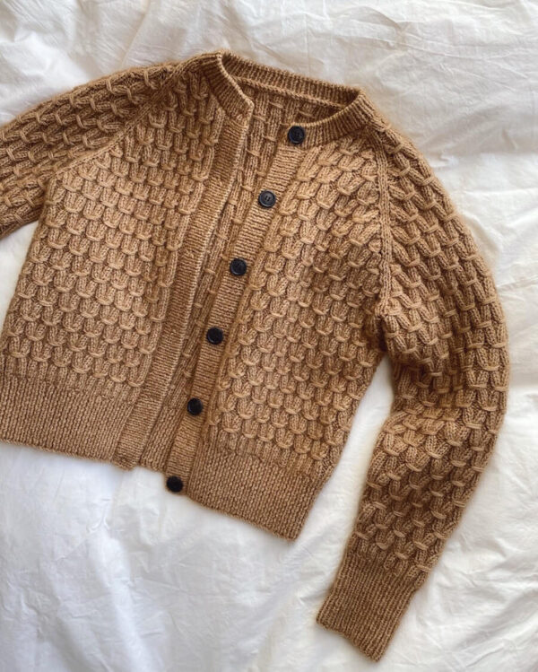 PetiteKnit Jenny Jacket tasolle levitettynä. Ohje on englanninkielinen. Neuletakissa on pintakuviota.
