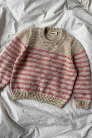 PetiteKnit Lyon Sweater Junior, tasolle levitettynä. Raidallinen lasten neulepusero, väreinä vaalea beige ja vaalenpunainen