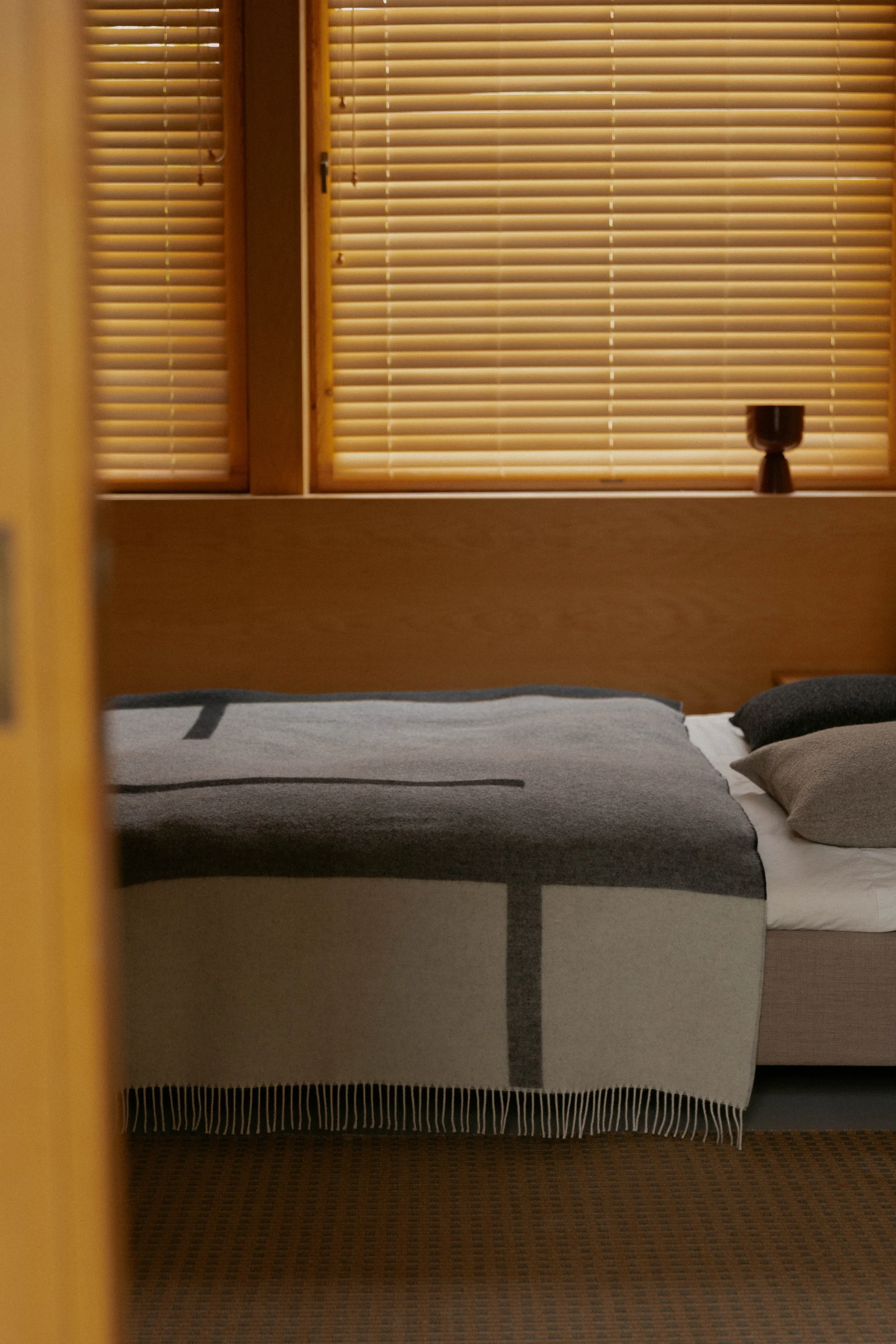 Kuvassa Suunta-huopa on päiväpeitteenä sängyn päällä.