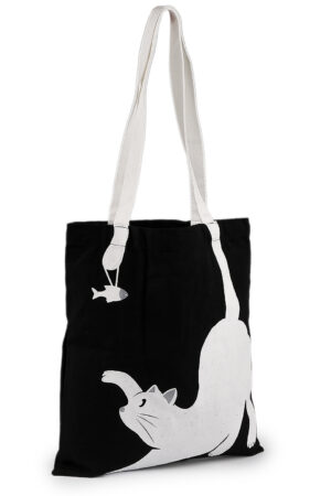 Musta puuvillakassi, jossa on valkoiset kahvat. Mustaan pohjaan on painettu valkoinen kissa, joka havittelee pientä kalaa.